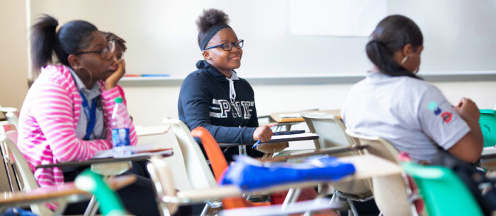 Students sitting at their desks in a classroom.