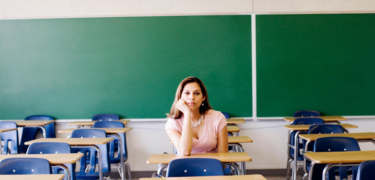 A woman sitting in the middle of a classroom.