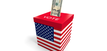 A 20 dollar bill is put into a box with an american flag on it and the word "vote."