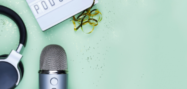 A sign reading "podcast" sits above a microphone and headphones.