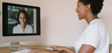Two women talk through a video conference.