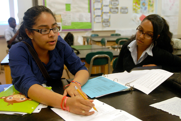 A NAF Academy of Finance educator helps a student with an in-class assignment