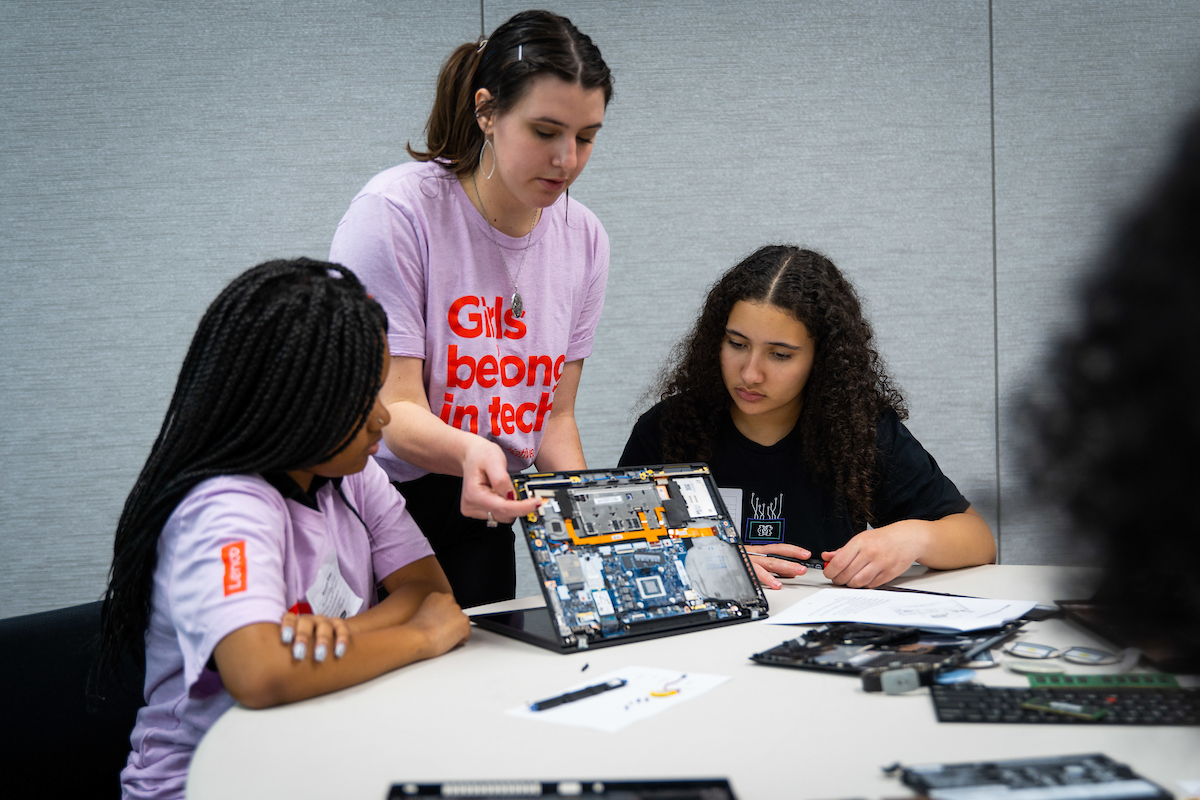 A Lenovo staff member volunteers at a Girls Belong in Tech event to teach students about STEM through hands-on learning