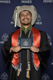 Eduardo Ramirez holding his diploma from Colorado School of Mines.